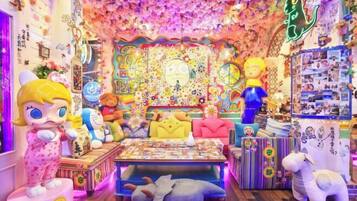 Um quarto vibrante com uma tapeçaria colorida, brinquedos macios e diversos objetos decorativos.