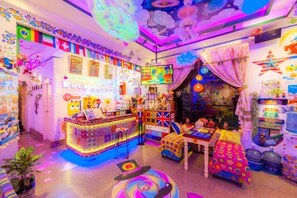 A brightly lit room with a colorful interior, a reception desk, and various items on display. - Yanbang·Fantasy Art Designer Homestay (West Street) (Yangshuo)