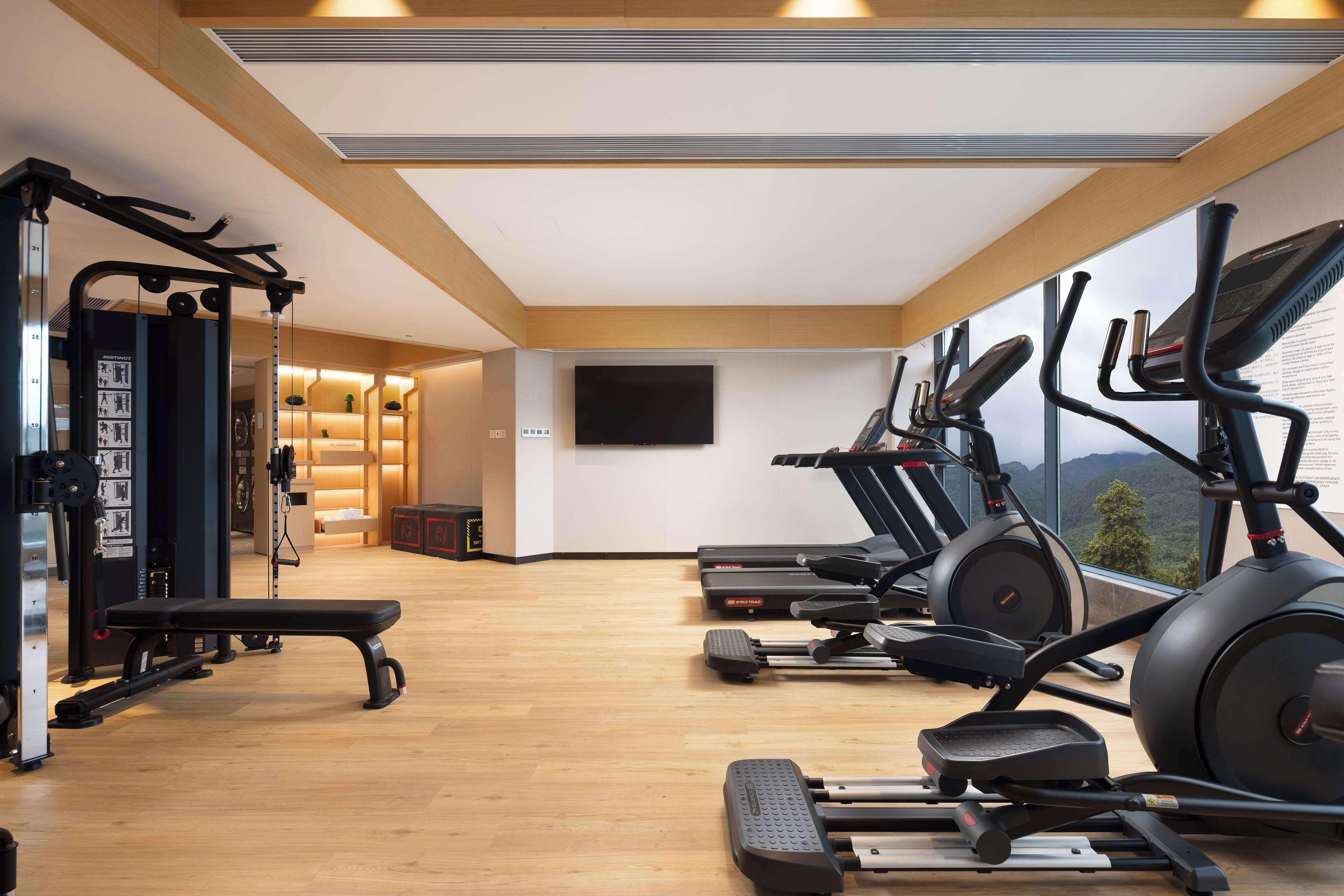 A gym with treadmills, elliptical machines, and weightlifting equipment.