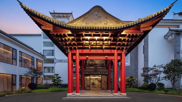 A traditional Chinese pavilion with red pillars and a hexagonal roof, surrounded by modern buildings. - Hilton Garden Inn Dali Ancient City (Dali)