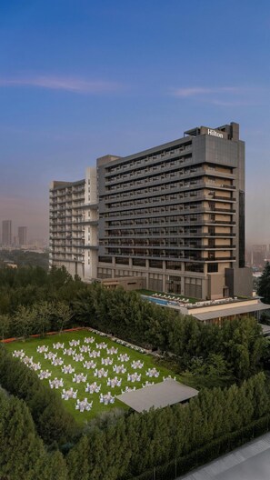 A modern hotel with multiple floors and a rooftop pool area.
