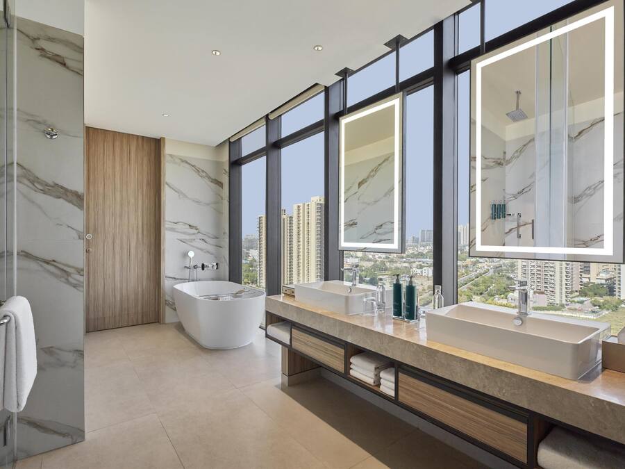 Un baño moderno con una bañera grande, dos lavamanos y un espejo amplio.