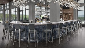 Een moderne bar met een gebogen toonbank, diverse barkrukken en een opvallende bolvormige lamp.