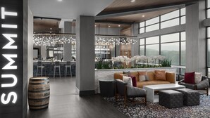 Een moderne lounge met een bar, zitplaatsen en grote ramen met uitzicht.