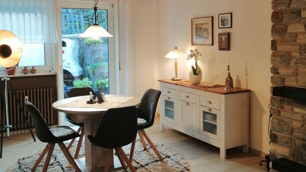 A cozy dining area with a round table, black chairs, and a wooden ceiling. - Gemütliche, Ruhige Ferienwohnung in Waldreicher Umgebung , 30 km bis Heidelberg (Schönbrunn)