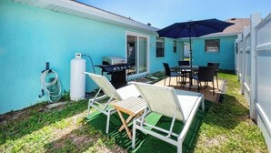 A backyard with a grill, outdoor seating, and a hose. - Charming villa with 2 bedrooms, 4 miles from gulf beaches. Dogs welcome!  (Englewood)