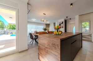 Enjoy meals at the dining table and island, with an outdoor space accessible through the sliding glass door.
