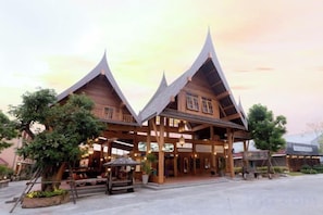 A traditional wooden building with a covered entrance and a patio area. - Naina Resort & Spa Phuket (Phuket)
