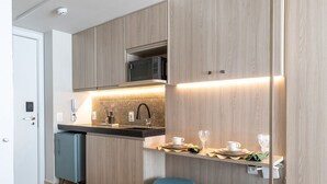 A modern kitchen with wooden cabinets, a microwave, and a bar area with stools. - Setai Yacht By Day by Day (João Pessoa)