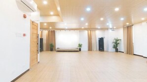 A spacious room with a wooden floor, a bench, a potted plant, and a door. - RedDoorz @ RJs Bldg near Lyceum Gen Trias Cavite (General Trias)