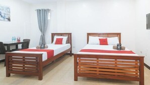 A hotel room with two wooden beds, a desk, and a chair. - RedDoorz @ RJs Bldg near Lyceum Gen Trias Cavite (General Trias)