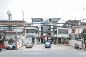 A commercial building with multiple storefronts, including a pharmacy and a cafe. - RedDoorz @ RJs Bldg near Lyceum Gen Trias Cavite (General Trias)