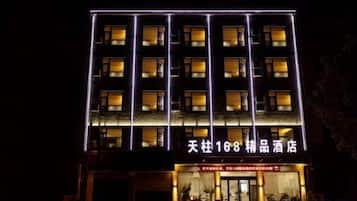 A multi-story hotel with illuminated signage and a ground-level entrance.