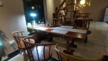 A dining area with a wooden table, chairs, and a bright lamp.