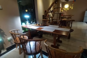 A dining area with a wooden table, chairs, and a bright lamp. - Jiahao Meisu Hotel (Guilin Jinshan Square) (Guilin)