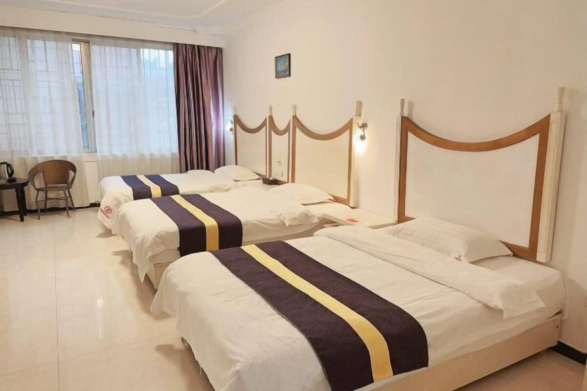 Habitación de hotel con dos camas, un escritorio y una silla.