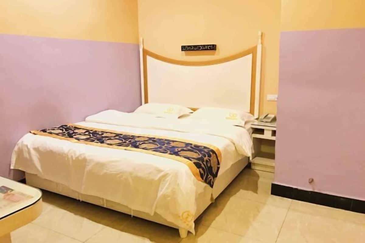 Una cama individual con cabecera, una mesita de noche y un tocador.
