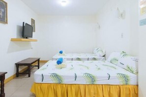 A hotel room with two beds, a TV on a shelf, a small table, and a bench. - Golden Success Hotel I by RedDoorz (Paniqui)