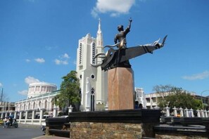 Una estatua sobre un pedestal, con una iglesia al fondo.