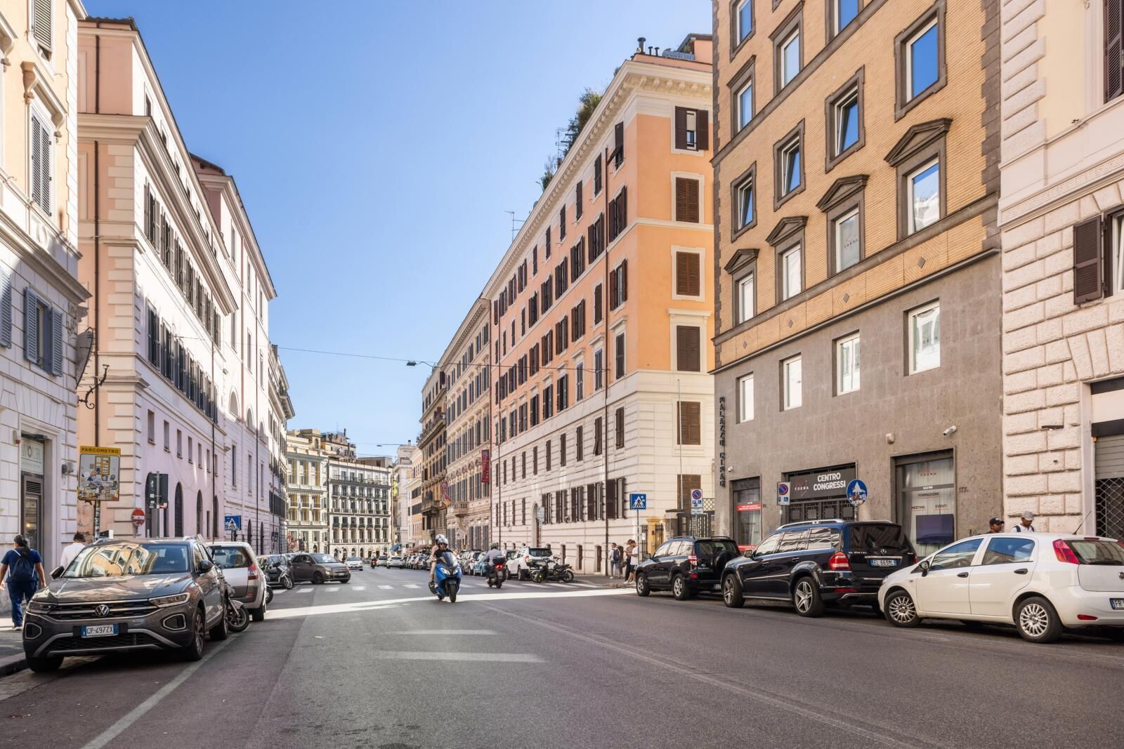 A street lined with multi-story buildings, some with commercial establishments on the ground floor.