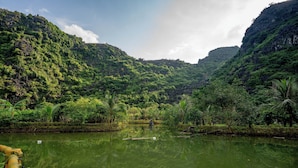 A serene river surrounded by lush greenery and hills. - The Goat Boutique Resort (Tay Hoa Lu)