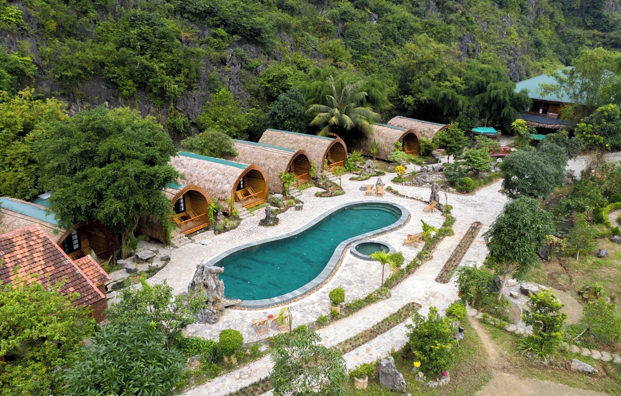 A resort with thatched-roof cottages, a central pool, and lush greenery.