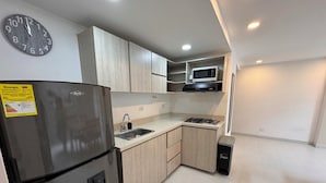 A modern kitchen with a stainless steel refrigerator, a microwave, and a sink.