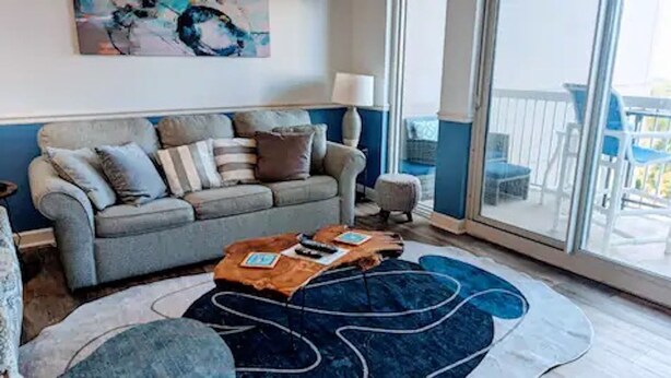 Ein Wohnzimmer mit einer Couch, einem Couchtisch und einem großen Fenster.