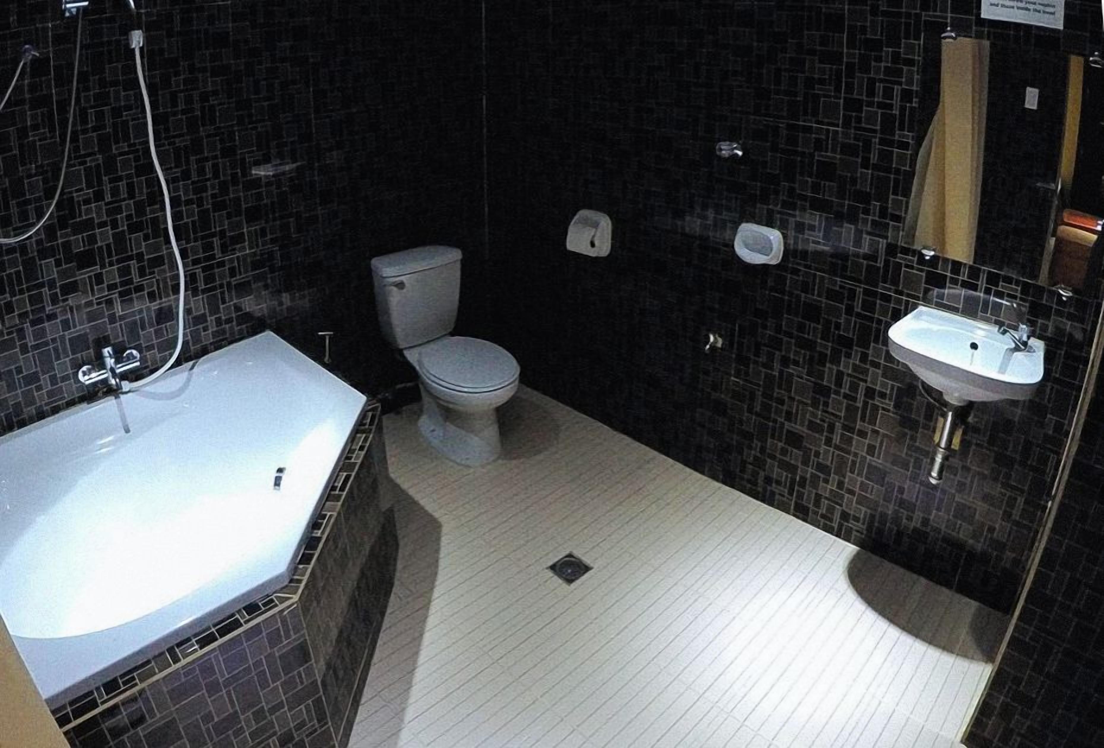 A bathroom with a white toilet, a sink, and a bathtub.