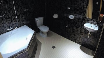 A bathroom with a white toilet, a sink, and a bathtub.