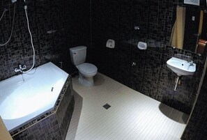 A bathroom with a white toilet, a sink, and a bathtub. - Reddoorz Plus @ Taj Hotel Tuguegarao (Tuguegarao)