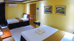 Une chambre d’hôtel avec deux lits, un bureau et un téléphone.