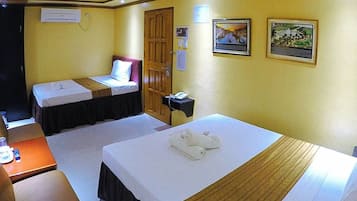 A hotel room with two beds, a desk, and a telephone.