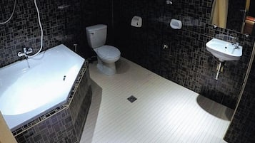 A bathroom with a bathtub, toilet, and sink.