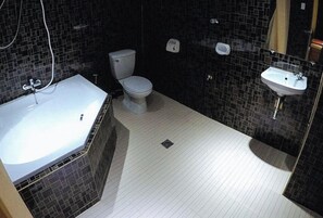 A bathroom with a bathtub, toilet, and sink. - Reddoorz Plus @ Taj Hotel Tuguegarao (Tuguegarao)