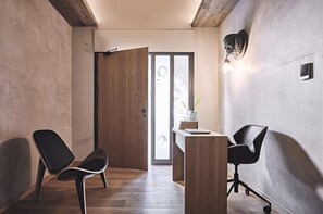 A modern interior with a wooden door, a desk with a laptop, and two black chairs. - O2 Suites Glyfada (Glyfada)