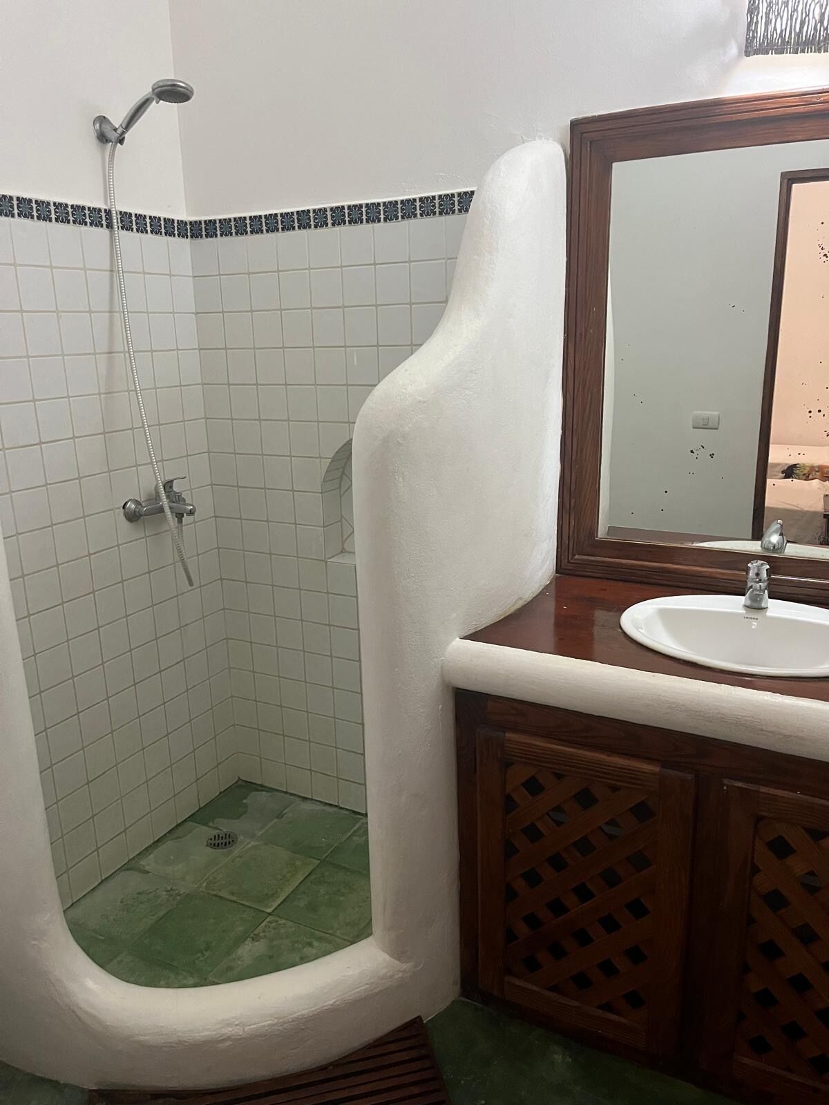 A bathroom with a shower, a sink, and a mirror.