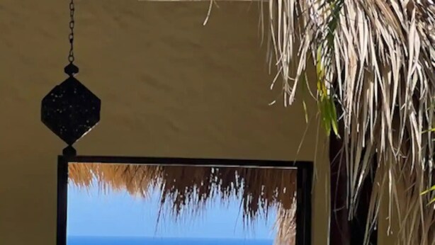 A room with a view of a beach and ocean.