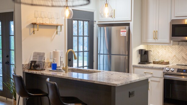 A modern kitchen with a large island, stainless steel appliances, and pendant lighting. - Golf Course Views, Sunsets & Chill Vibes (Lowndes County)