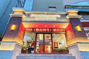 A hotel entrance with a sign for Star Holiday Hotel and a contact number. - Starlight Holiday Hotel (Zhengzhou Erqi Square Dongda Street Subway Station Branch) (Zhengzhou)