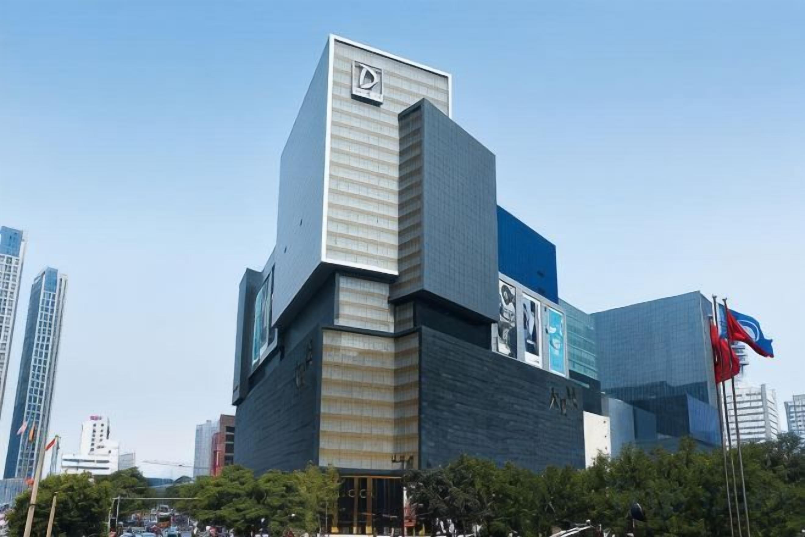 Un edifici modern amb una secció vertical destacada i una gran pantalla digital.