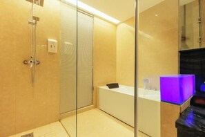 Une salle de bain moderne avec une douche à l’italienne en verre, une baignoire blanche et un meuble-lavabo éclairé en bleu.
