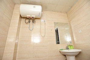 Ein Badezimmer mit Toilette, Waschbecken, Spiegel und Dusche.