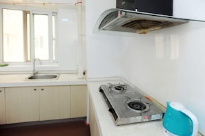 Une cuisine équipée d’une cuisinière à gaz, d’une fenêtre et d’un évier.