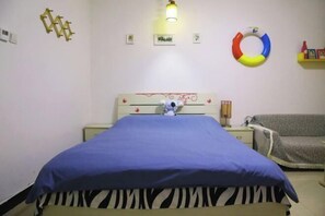 A bedroom with a bed, a bedside table, a lamp, a wall decoration, and a couch. - Mizilan Zhengzhou Hotel (Guomao 360) (Zhengzhou)