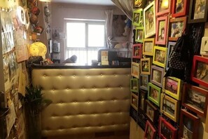 Une chambre dotée d’une tête de lit capitonnée, d’une fenêtre offrant une belle vue et d’un mur orné de tableaux encadrés.