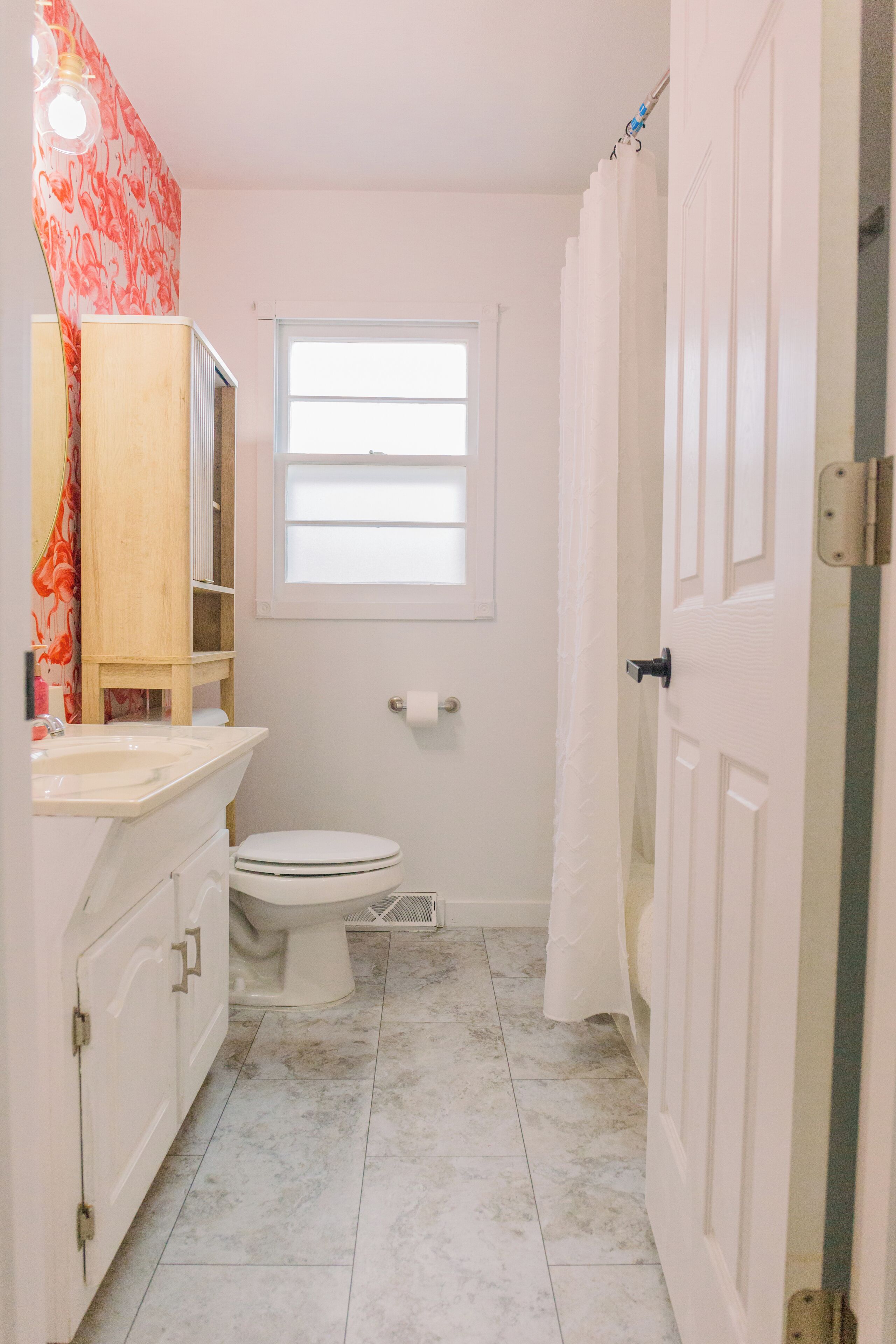 A small bathroom with a toilet, sink, and shower curtain.
