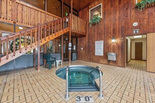 A wooden interior with a pool, a staircase, and a sign indicating a 30 ft depth.