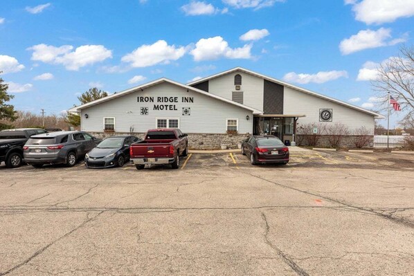 A motel with a sign reading "IRON RIDGE INN MOTEL" and a parking lot with several cars.