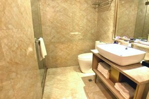 A bathroom with a marble floor, a white sink, a toilet, and a mirror. - Biz Boutique Hotel (Hangzhou)